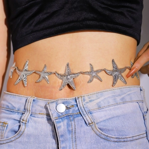 Detailaufnahme einer glänzenden silbernen Seestern-Bauchkette an der Taille mit Jeans
