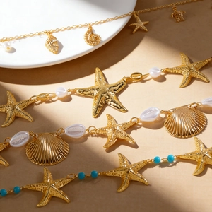 Nahaufnahme von goldenen Taillenketten mit Seestern- und Muschelmotiven für den Urlaub