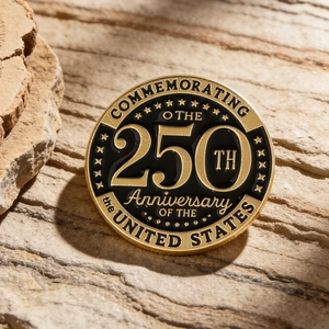 Detalle del pin conmemorativo del 250 aniversario de EE. UU. sobre una piedra