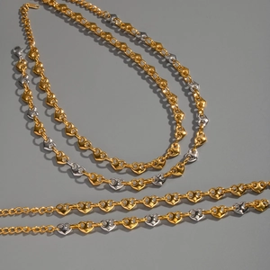 Detail of mixed gold and silver heart-shaped chain links with lobster clasp closure
