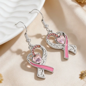 Details von Herz-Ohrringen mit rosa Schleife und Kristallen auf Satinhintergrund