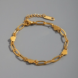 Detail of gold paperclip chain bracelet with polished heart charms and lobster clasp