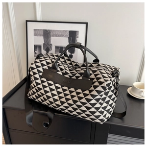 Vue détaillée du grand sac de voyage en toile avec motifs géométriques et étiquette Moon Bag
