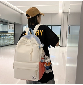 Detail view of large nylon backpack with adjustable straps and cute cow plush pendant