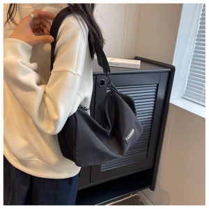 Detail of nylon crossbody bag with wide strap and white Fashion label tag