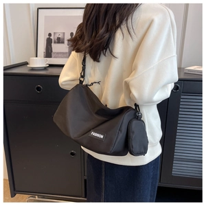 Detail of black nylon shoulder bag with side round pouch and fashion label