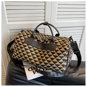 Détail du sac de voyage en toile avec motifs jacquard géométriques noir et beige