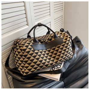 Gros plan du grand sac de voyage en toile avec motifs géométriques et anses en cuir noir