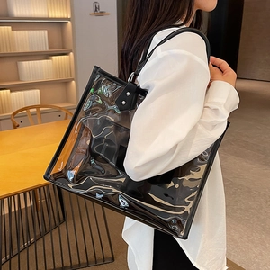 Bolso tote transparente de PVC con bolsa interior negra y correa sobre modelo de moda