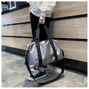 Detail einer champagnerfarbenen Reisetasche aus wasserfestem Nylon mit Tragegriffen