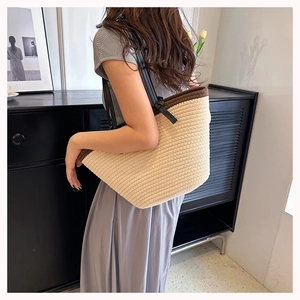Detail of woven tote bag with contrast piping and slim leather shoulder straps