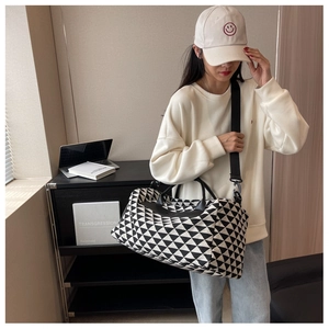 Vue détaillée du grand sac de voyage en toile avec motifs géométriques noir et blanc