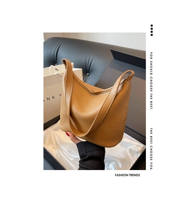 Close-up of tan lychee grain leather bucket bag presented in a luxury gift box