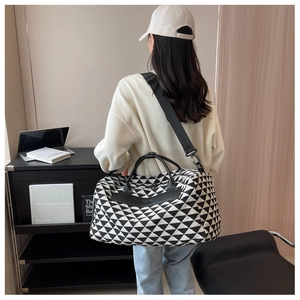 Grand sac de voyage en toile géométrique avec sangles en cuir porté par un mannequin