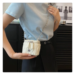 Details der weißen Stepptasche mit floralem Metallverschluss und Kettenriemen für Damen