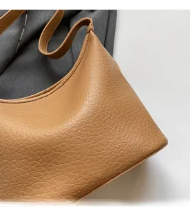 Close-up of brown litchi pattern leather bucket bag with soft texture and refined grain