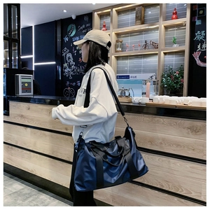 Detailansicht der dunkelblauen Reisetasche aus Oxford-Stoff mit Tragegurt am Model