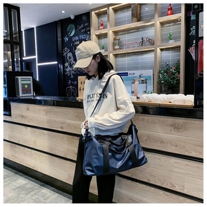 Detailansicht der geräumigen marineblauen Oxford-Reisetasche mit verstellbarem Gurt im Cafe