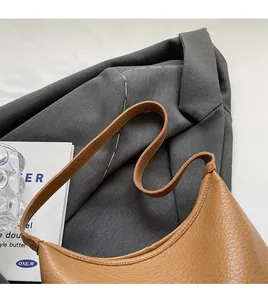 Close-up of caramel brown lychee leather bucket bag with a comfortable wide strap