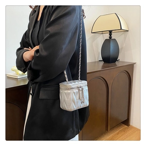 Detailaufnahme einer silbernen Stepptasche mit Kette, die Textur und Design zeigt