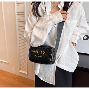 Detail of black crossbody bag with gold SMILEDT text and adjustable wide strap