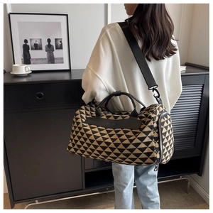 Gros plan du sac de voyage en toile aux motifs géométriques noirs et jaunes vifs