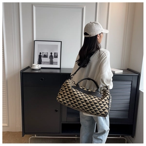 Détail du grand sac de voyage en toile avec imprimé géométrique et lanières en cuir