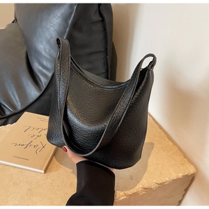 Close-up of black lychee-textured hobo bucket bag showing grainy leather detail