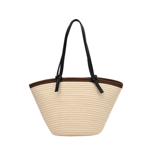 Minimalist beige woven tote bag with dark brown trim and knotted black leather straps