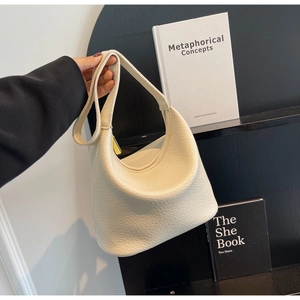 Detail of off-white pebbled leather hobo bag with gold hardware and wide shoulder strap
