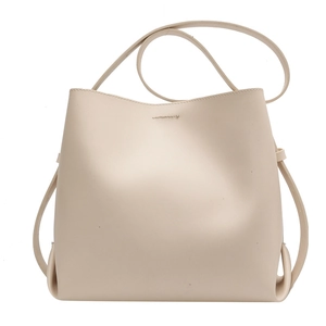 Minimalist beige high-capacity bucket bag with matte leather finish and long shoulder strap