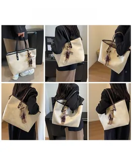 Détail du grand sac cabas beige avec anses contrastées noires et charm lapin mignon