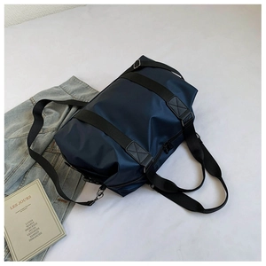 Detail der wasserdichten dunkelblauen Oxford-Reisetasche mit schwarzen Griffen und Silber