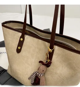 Détail du sac cabas beige plissé avec breloque lapin marron et fermeture éclair