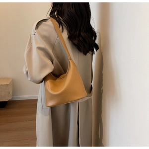 Minimalist camel hobo bag with pebble leather texture shown on shoulder for daily commute