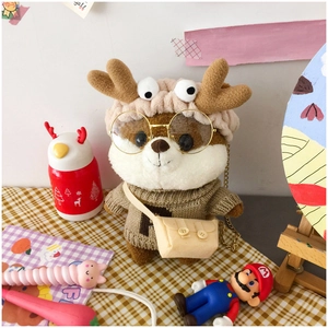 Dettaglio di peluche scoiattolo con maglione marrone lavorato a maglia e occhiali dorati