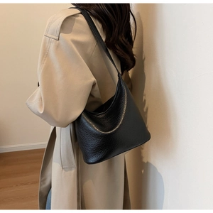 Detail view of black litchi grain leather hobo bag showing texture and soft shoulder drape
