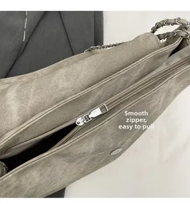 Detail of smooth silver zipper and matte texture on a stylish underarm chain bag