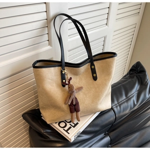 Détail du grand sac cabas beige avec lanières noires contrastées et breloque lapin