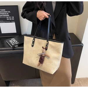 Détail du sac cabas beige avec anses noires et charmant petit lapin marron attaché