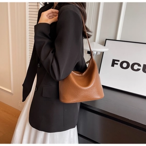Close-up of brown litchi pattern leather bucket bag with slim shoulder strap design