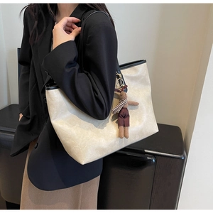 Détail du sac cabas à texture marbre avec bordure noire et breloque lapin en peluche