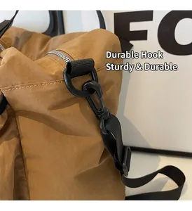 Nahaufnahme von robustem schwarzem Kunststoffhaken und Schultergurt an khakifarbener Tasche