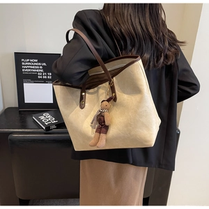 Détail du grand sac cabas crème avec anses marron et peluche lapin attachée