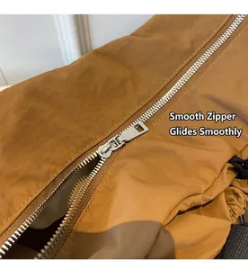 Detailaufnahme des glatten silbernen Metallreißverschlusses an der braunen Reisetasche