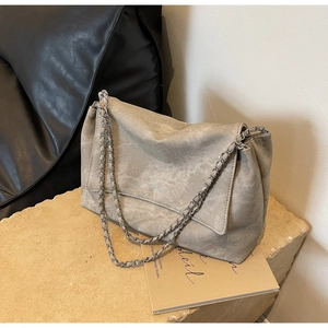 Detail shot of grey tote bag with silver chain strap and matte distressed texture
