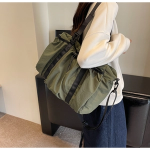 Details der olivgrünen Nylontasche mit verstellbarem Gurt und Kordelzug-Verschluss