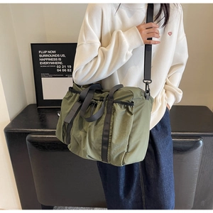 Detail der armee-grünen Nylon-Reisetasche mit Seitentasche und breitem Schultergurt-Design