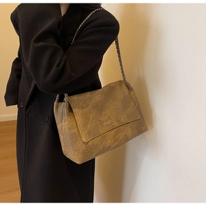 Detail of caramel brown retro chain shoulder bag with distressed leather texture