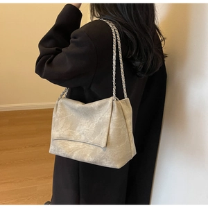 Detail of grey marble texture shoulder bag with silver chain strap on model